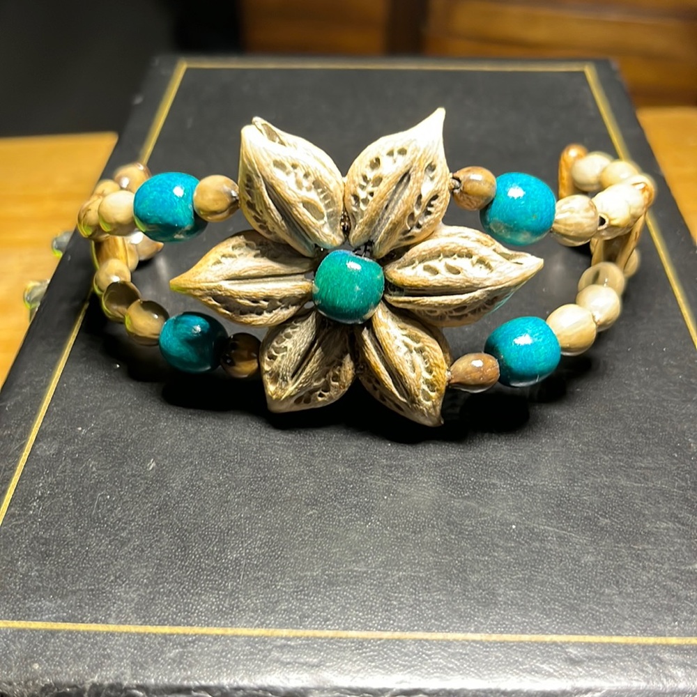Like new. Nut shell adjustable bracelet.   Tan and aqua. Lightweight.